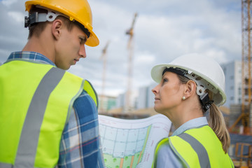 View of a Engineer and worker checking plan on construction site