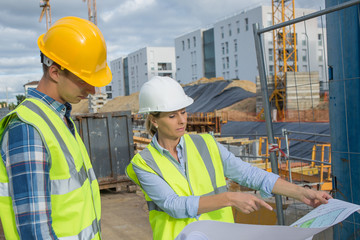 View of a Engineer and worker checking plan on construction site
