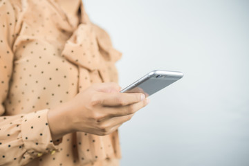 asian businesswoman using smart phone on gray background.