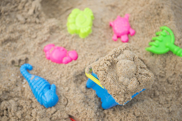 Fototapeta na wymiar colorful toys for kids on sand