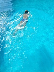Obraz na płótnie Canvas child swimming in blue water