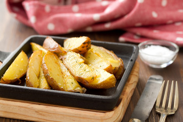 fried potato with salt, fork and knife