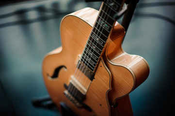 six-string acoustic guitar on a stand - Powered by Adobe