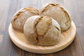 bread on wooden dish on brown background
