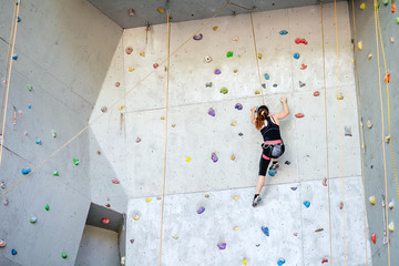 Woman making effort when climbing indoors