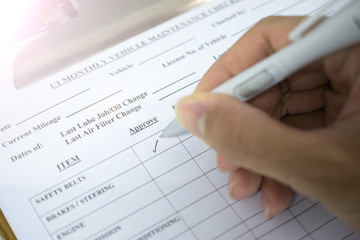 hand with pen over checklist form