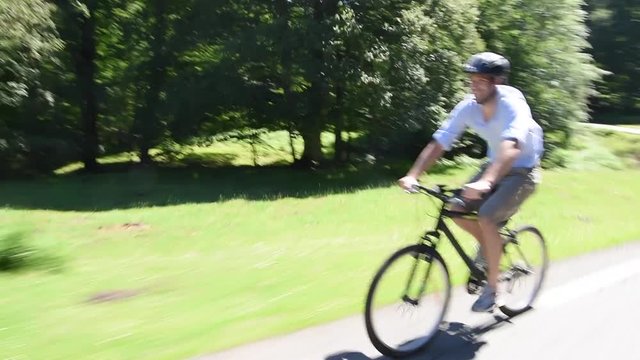 man riding bike down mountain road