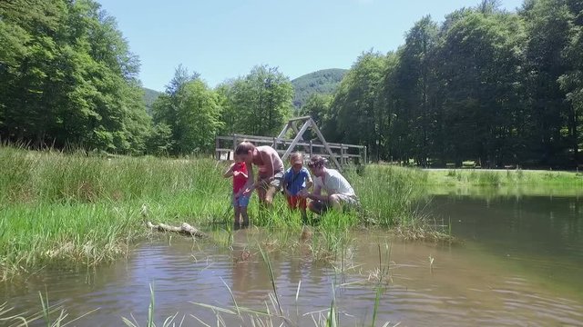 Family in lake looking for tadpoles