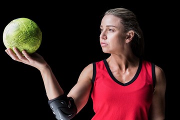 Female athlete with elbow pad holding handball