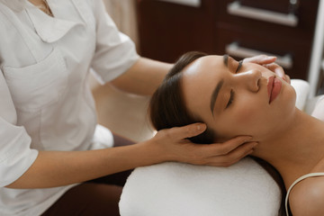 Fototapeta na wymiar Spa Massage. Beautiful Woman Getting Facial Beauty Treatment