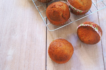 Top view of homemade banana cupcakes on a rack on a wooden table