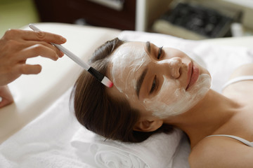 Obraz na płótnie Canvas Facial Beauty Treatment. Beautiful Woman Getting Cosmetic Mask