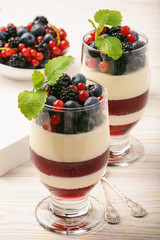 Layered berry dessert - panna cotta with berry jelly, blueberries,blackberries and red currants.