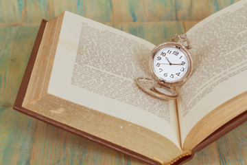 Pocket Watch over Age Book Background ,Time