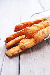 Close up of crispy cheese bread sticks on a wooden table.