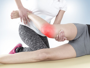 Fototapeta premium Doctor is stretching woman leg.