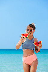 Woman eating watermelon on the beach