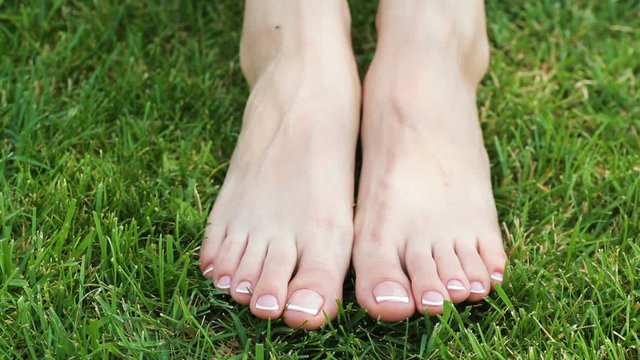 Closeup of a female feet with white french pedicure on nails