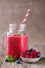 Healthy smoothie with raspberries, berries on plates and drinkin