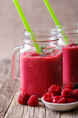 Summer smoothie in glass jar with berries plates.