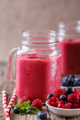 Healthy smoothie with raspberries, berries on plates and drinkin