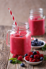 Healthy smoothie with raspberries, berries on plates and drinkin