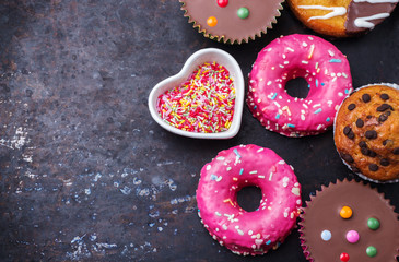 Fototapeta na wymiar Colorful donuts on a grunge rusty table