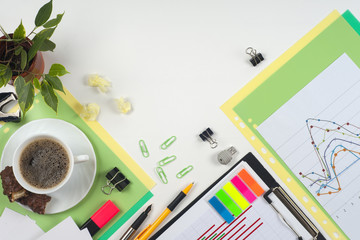 Office table desk with set of colorful supplies, white blank note pad, cup, pen, crumpled paper, flower on white background. Top view and copy space for text