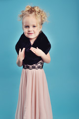 little girl in a long dress and a fur coat