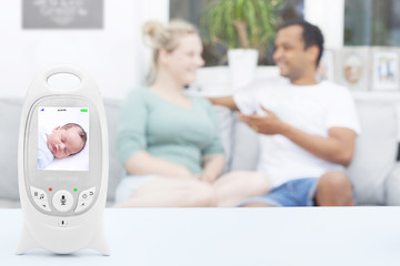 Interracial couple enjoying free time while baby is sleeping on baby monitor, copy space