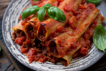 Close-up of cannelloni baked with minced meat in tomato sauce