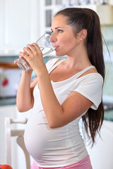 Pregnant woman with glass of water.