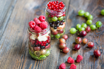 Summer berries smoothie in mason jar on rustic wooden table