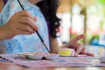 Naklejka premium Little hands of kid painting on the plaster soft focus.