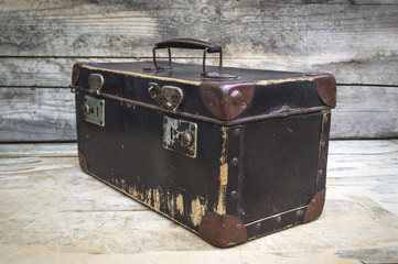 Vintage suitcase isolated on wooden table.