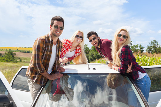 Friends on car roof outdoor countryside people smile