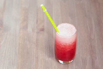 Watermelon smoothie in a glass on wooden table
