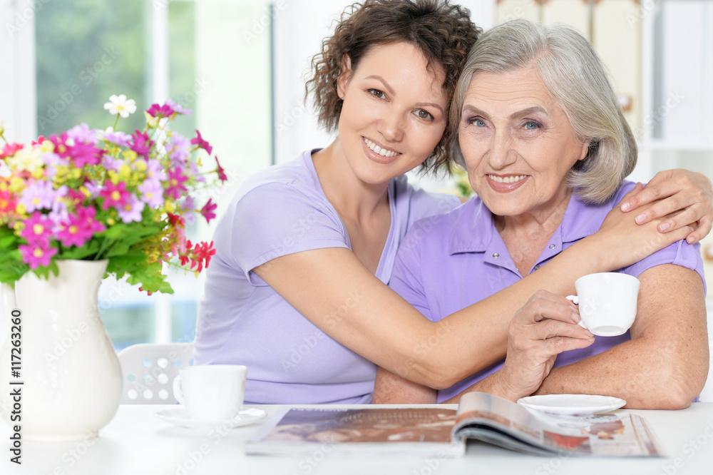 Poster Senior woman with daughter with magazine