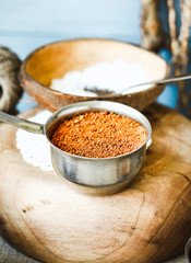 Coconut palm sugar in metal bowl and coconut flakes in shell