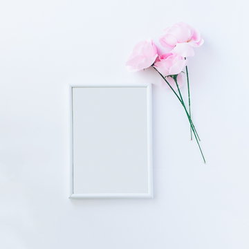 Empty picture frame with pink roses, top view