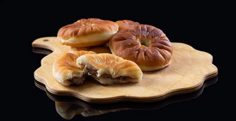 Traditional russian meat pies belyashi on black background