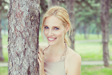 Beautiful blonde with blue eyes enjoying a walk in the forest