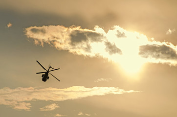 IAR Puma elicopter silhouette flying in the cloudy sky, stunt aerobatic show