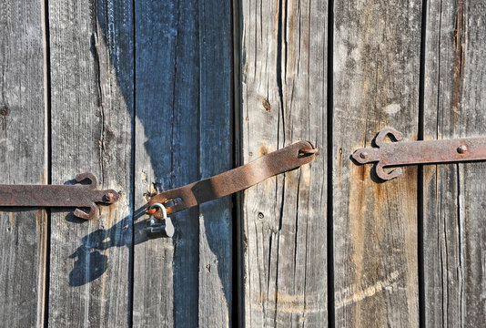 Rusty lock on old wooden gate