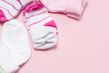 Cotton baby socks for newborn on a colorful pink background. Copy space for text. Top view