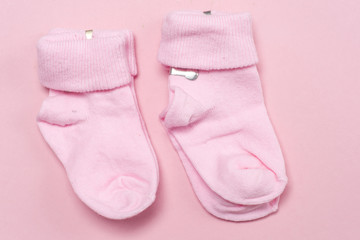 Cotton baby socks for newborn on a colorful pink background. Copy space for text. Top view