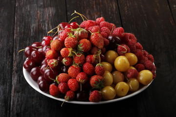 berries in plate on wooden background