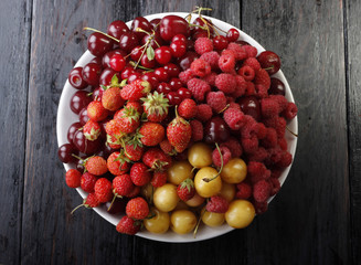 berries in plate on wooden background