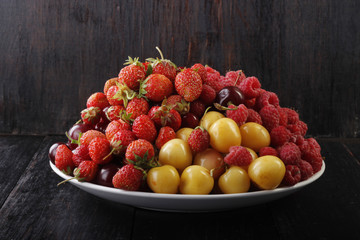 berries in plate on wooden background