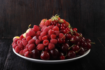 berries in plate on wooden background